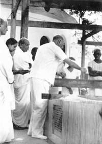 Nolini Kanta and André Morisset scattering rose petals on the Samadhi (20 November 1973).